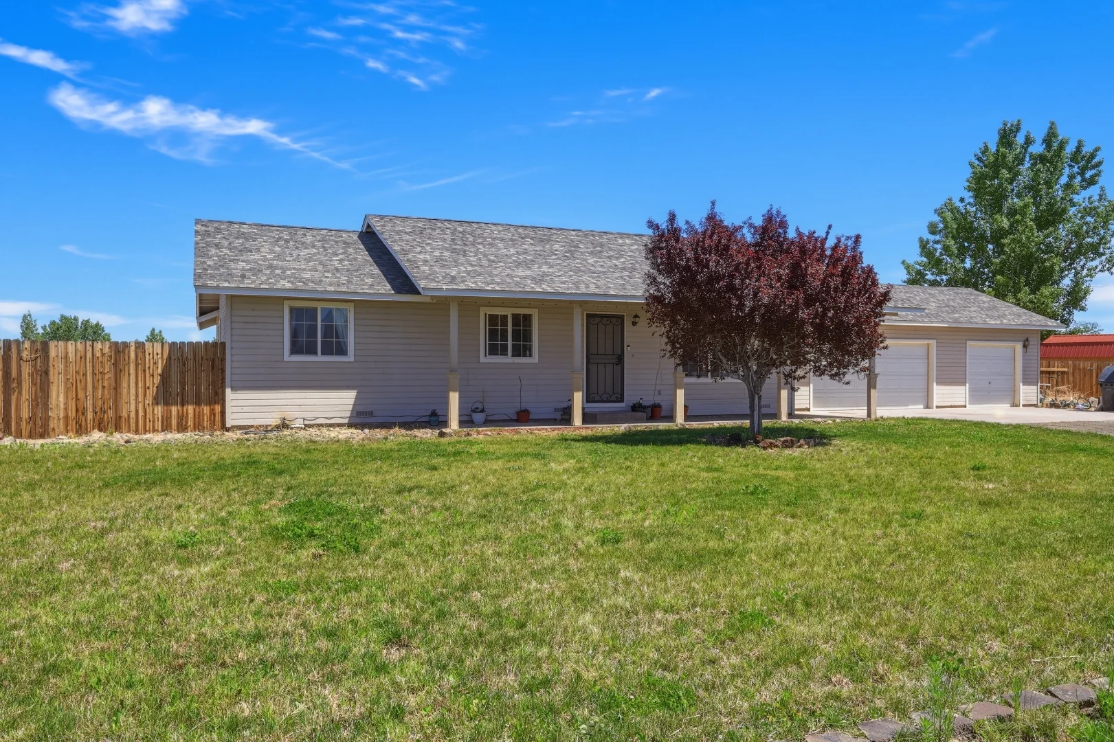 Front of home from the side showing covered porch and 3-car garage