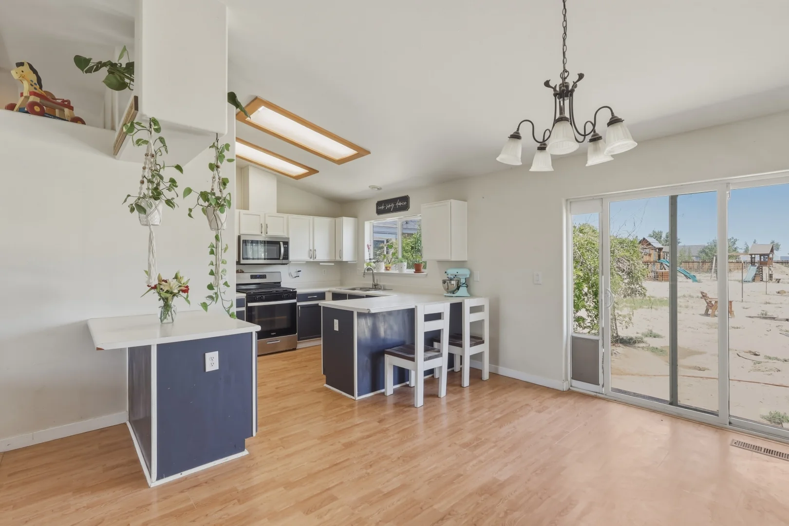 Kitchen with white cabinets, newer stainless steel appliances, and breakfast bar