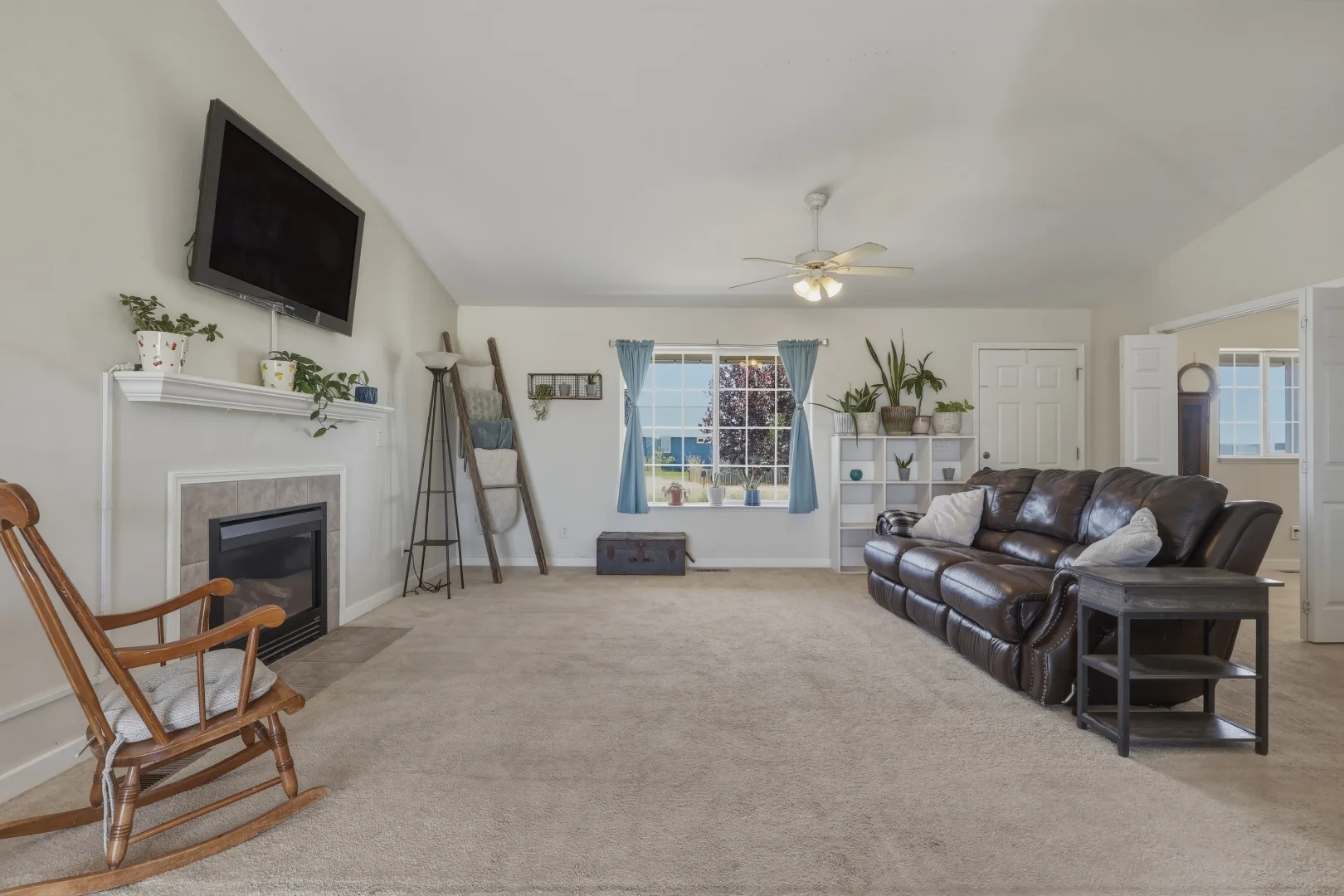 Great room with vaulted ceiling, tile-surround gas fireplace, and ceiling fan