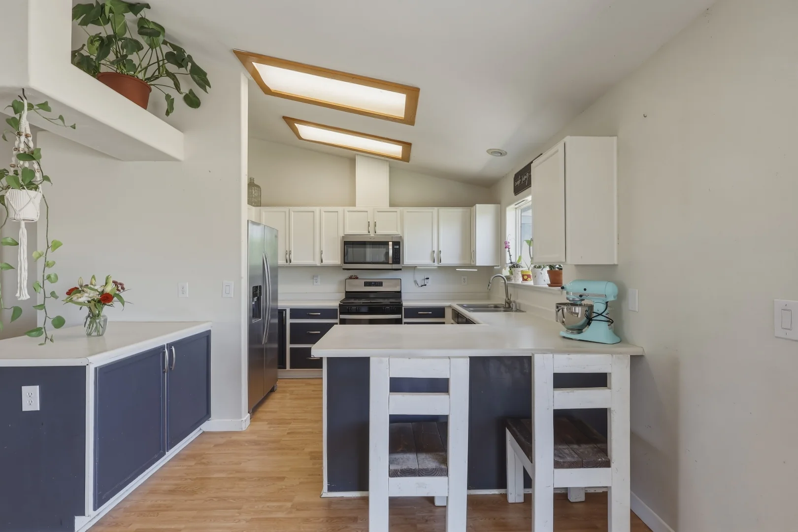 Kitchen detail with stainless refrigerator, gas range, and breakfast bar